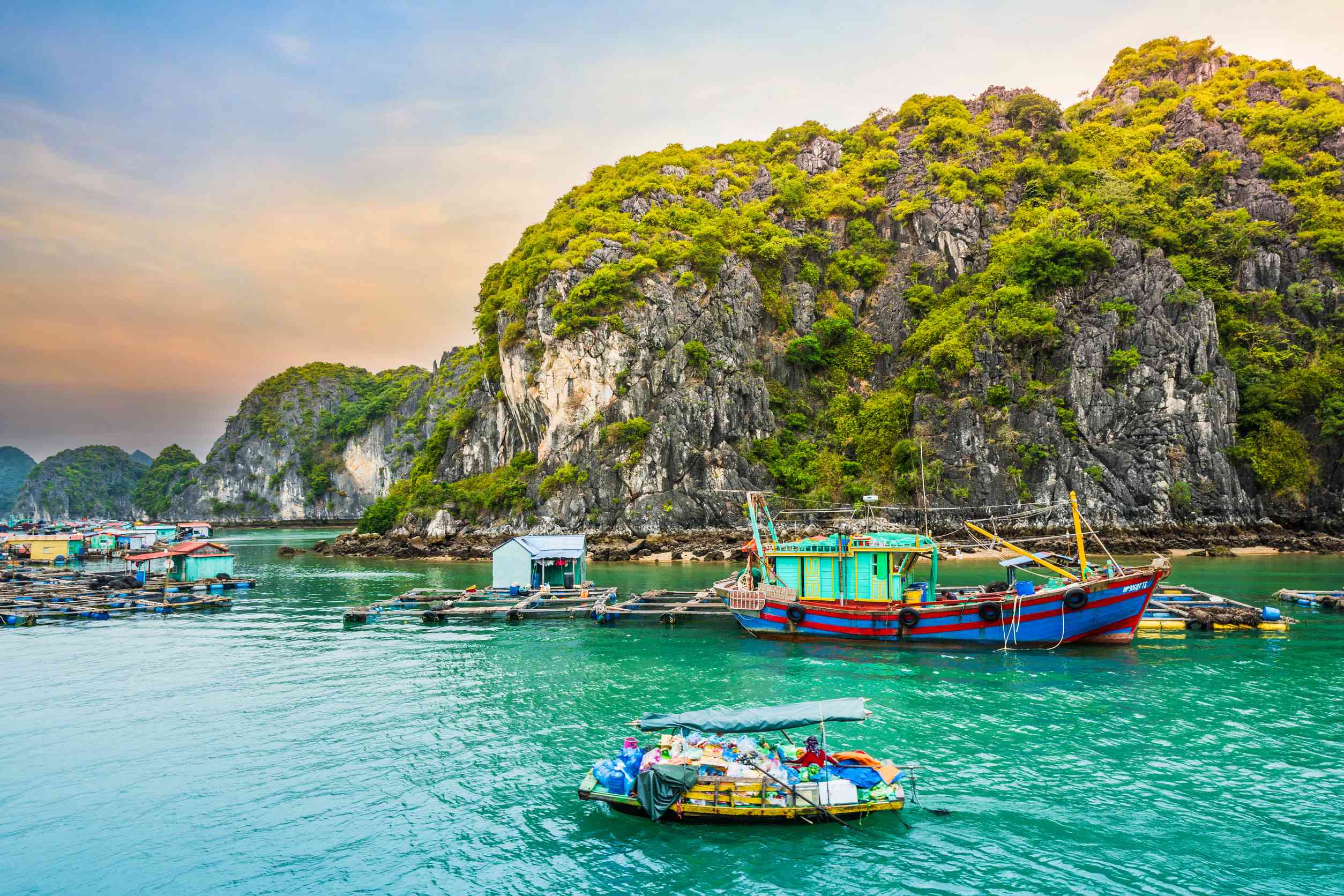 Boat at floating village of fishers and fish or oyster farmers in Halong Bay Vietnam