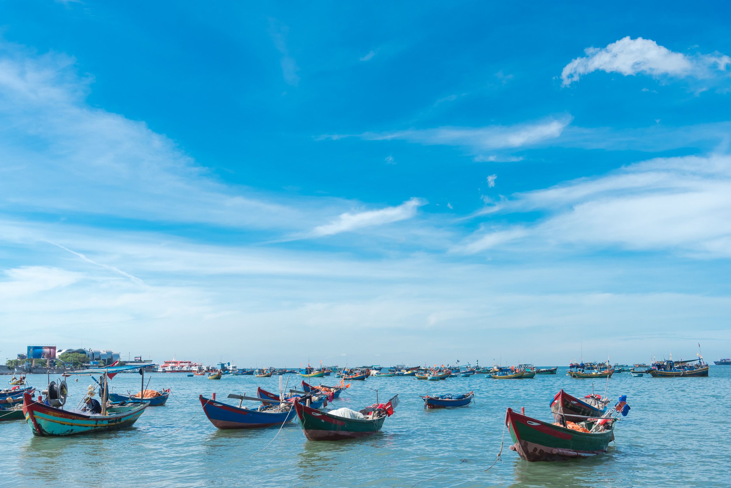  Fleet of small traditional wooden fishing boats anchored near shoreline of Bai Truoc beach